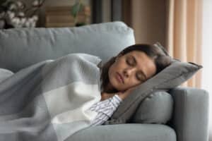 Woman resting on sofa after bone grafting surgery in Milwaukee, WI