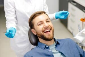 Man smiling in dentist chair during regular check for decay in Milwaukee, WI
