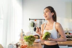 Woman smiling while eating healthy foods to preserve her dental crown in Milwaukee, WI