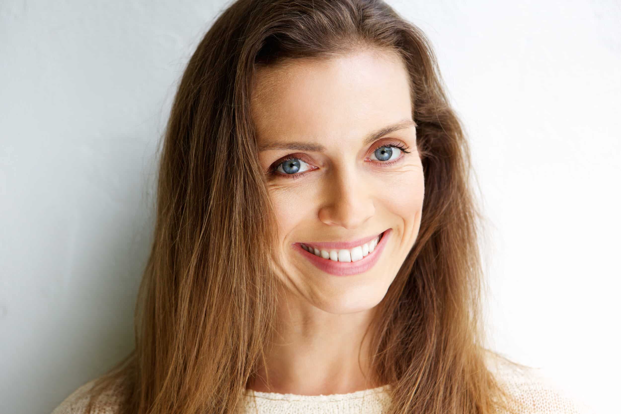 Woman smiling with complete smile after dental bone loss treatment in Milwaukee, WI